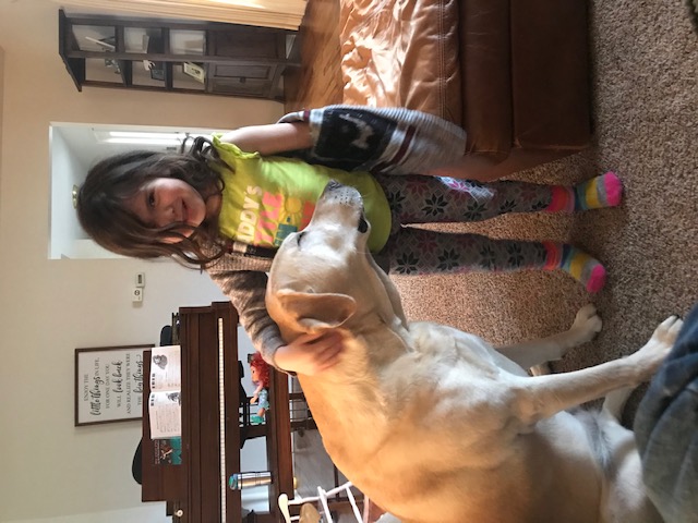 Charlie and Nora, a yellow lab and young girl